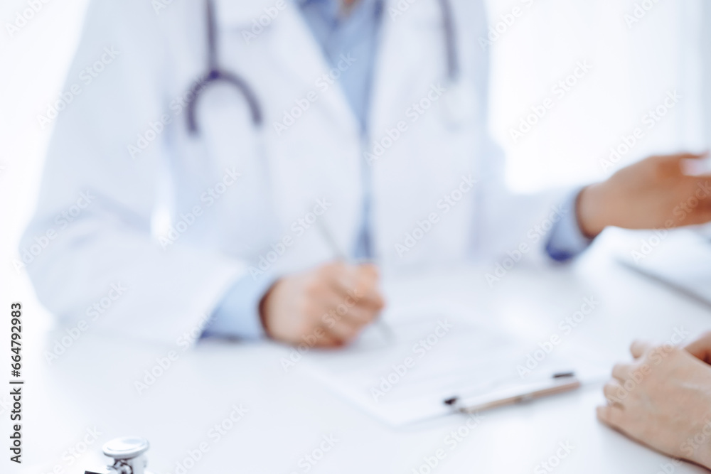 Stethoscope lying on the tablet computer in front of a doctor and patient sitting opposite each other at the background . Medicine, healthcare concept Stethoscope lying on the tablet computer in front of a doctor and patient sitting opposite each other at the background . Medicine, healthcare concept