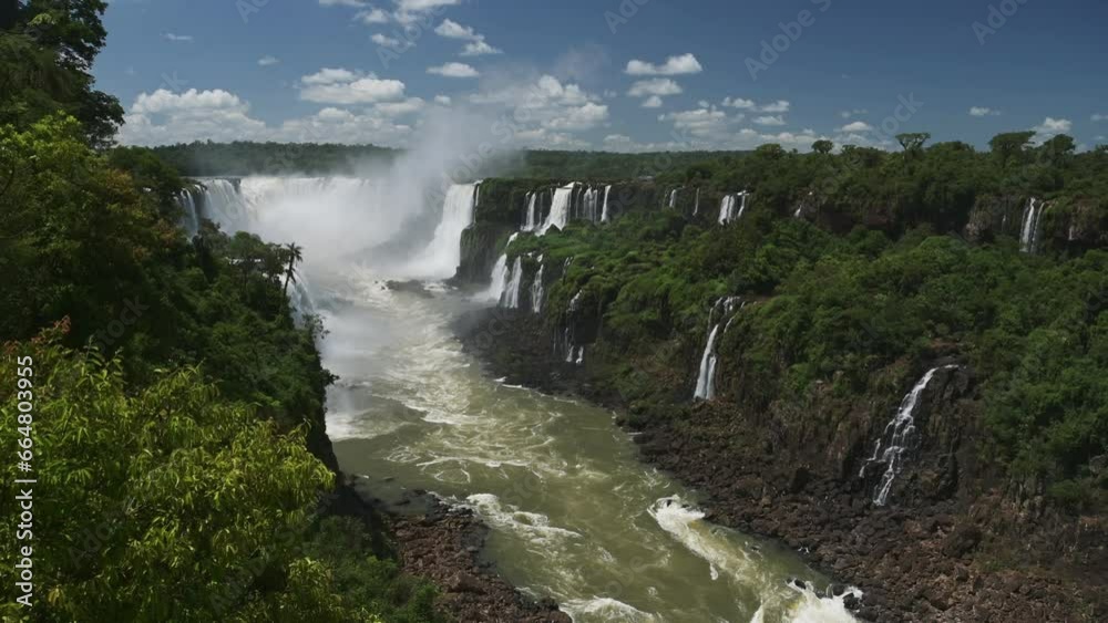Iguazu Falls Waterfall in Brazil, Wide Angle View of Waterfalls Deep in Rainforest, High Angle Slow Motion River Pouring Through Rugged Rock and Tall Trees in Rainforest Valley in Iguacu Falls Iguazu Falls Waterfall in Brazil, Wide Angle View of Waterfalls Deep in Rainforest, High Angle Slow Motion River Pouring Through Rugged Rock and Tall Trees in Rainforest Valley in Iguacu Falls