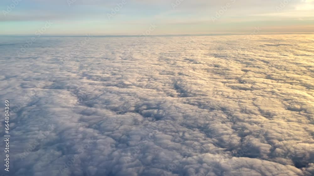 Aerial shot from airplane over the clouds at sunrise Aerial shot from airplane over the clouds at sunrise