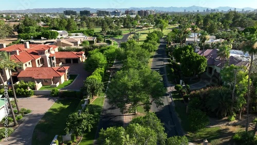 Mansions in country club neighborhood near Phoenix. Aerial establishing shot of prestigious houses with north Phoenix skyline in background. Arizona landscape. Biltmore Estates. photo