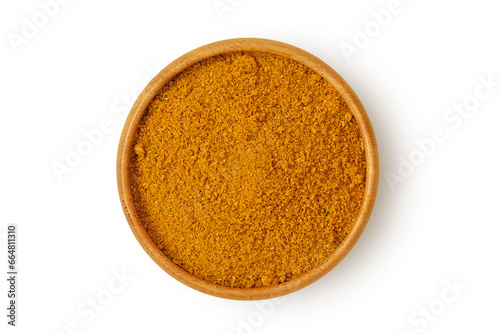 Curry powder in wooden bowl on white background