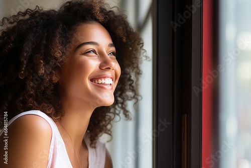 a woman smiling looking out a window