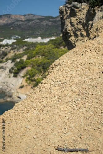 Vertical closeup of a sandy ground in sunlight near the sea