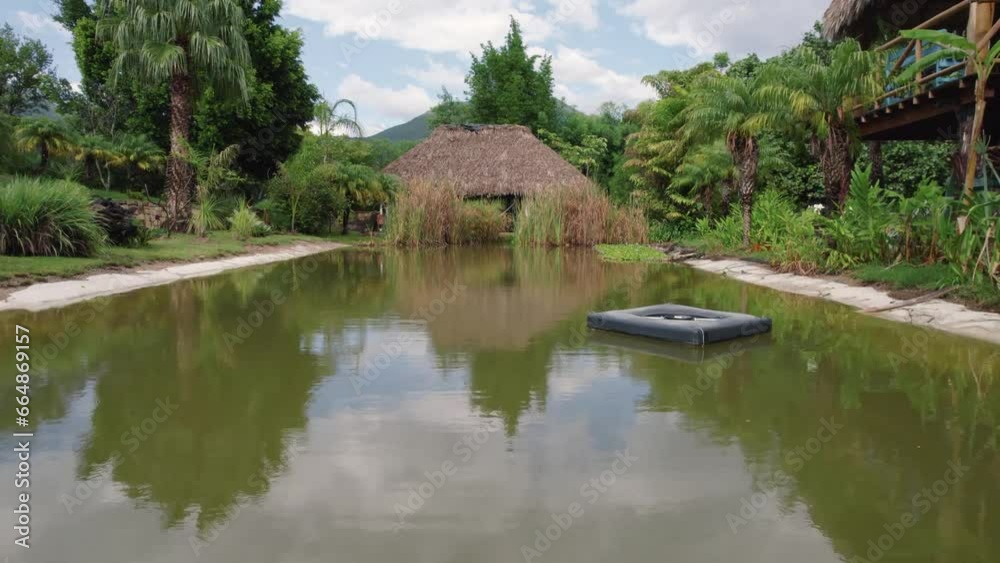 captivating aerial view as the camera glides forward, revealing a charming cabana overlooking a serene river. captivating aerial view as the camera glides forward, revealing a charming cabana overlooking a serene river.