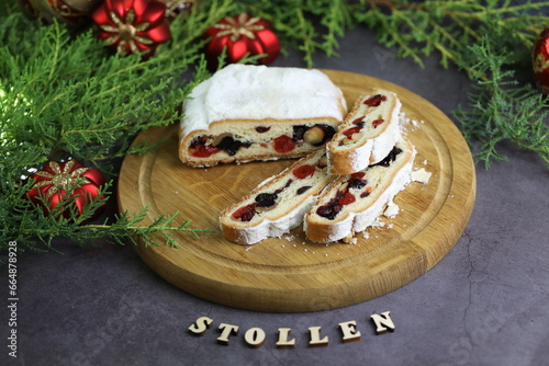 Sliced Chrismas stollen with powdered sugar and christmas decoration photo