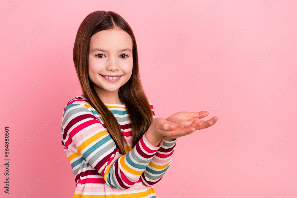 Photo of funny small girl holding two arms empty space advertising new games store advertise app store isolated on pink color background Photo of funny small girl holding two arms empty space advertising new games store advertise app store isolated on pink color background