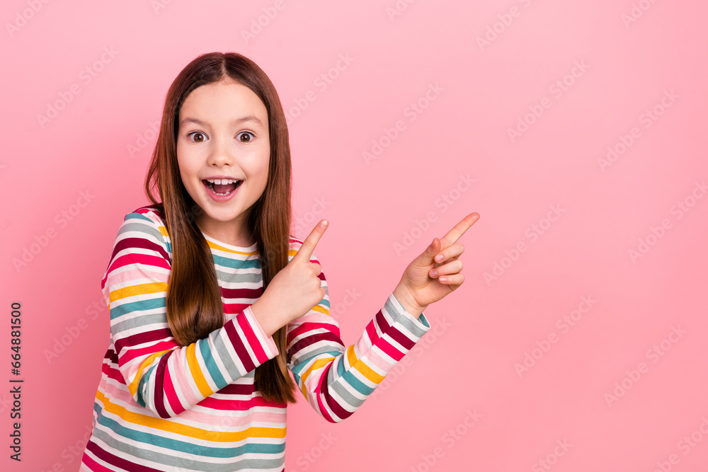 Photo portrait of little charming surprised omg reaction cute schoolgirl kid wow index fingers novelty isolated on pink color background Photo portrait of little charming surprised omg reaction cute schoolgirl kid wow index fingers novelty isolated on pink color background