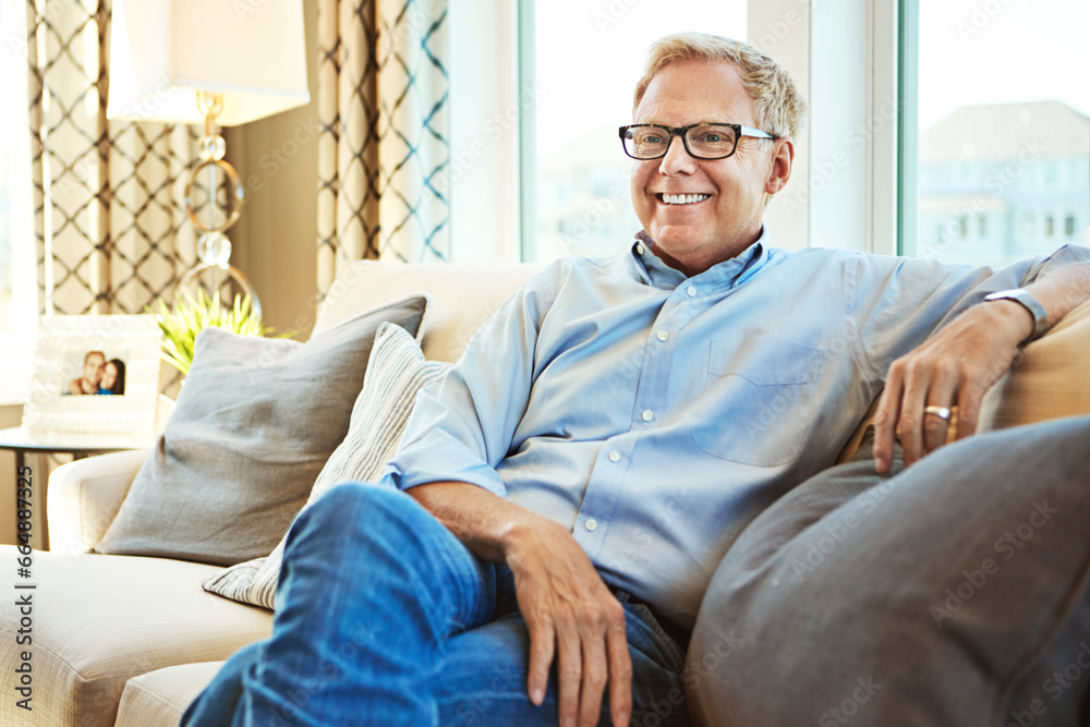 Thinking, mature or happy man on sofa to relax with calm on living room couch at home for resting. Ideas, glasses or senior male person with smile, peace or wellness in retirement, lounge or house