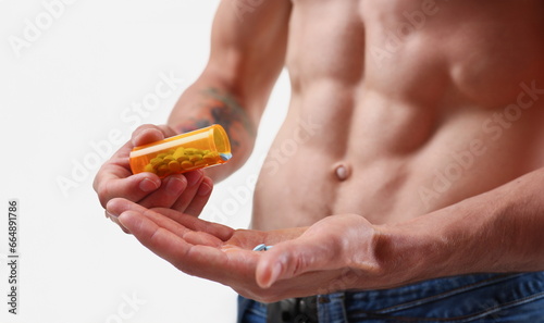 Fitness man pours pills from the jar into hand intake of hormonal preparations for rapid growth. Of doping muscles to achieve high results is experiencing problems with potency after closeup concept.