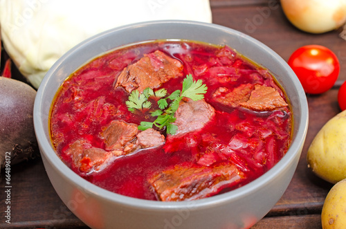 Borscht soup with vegetables and meat on a wooden table