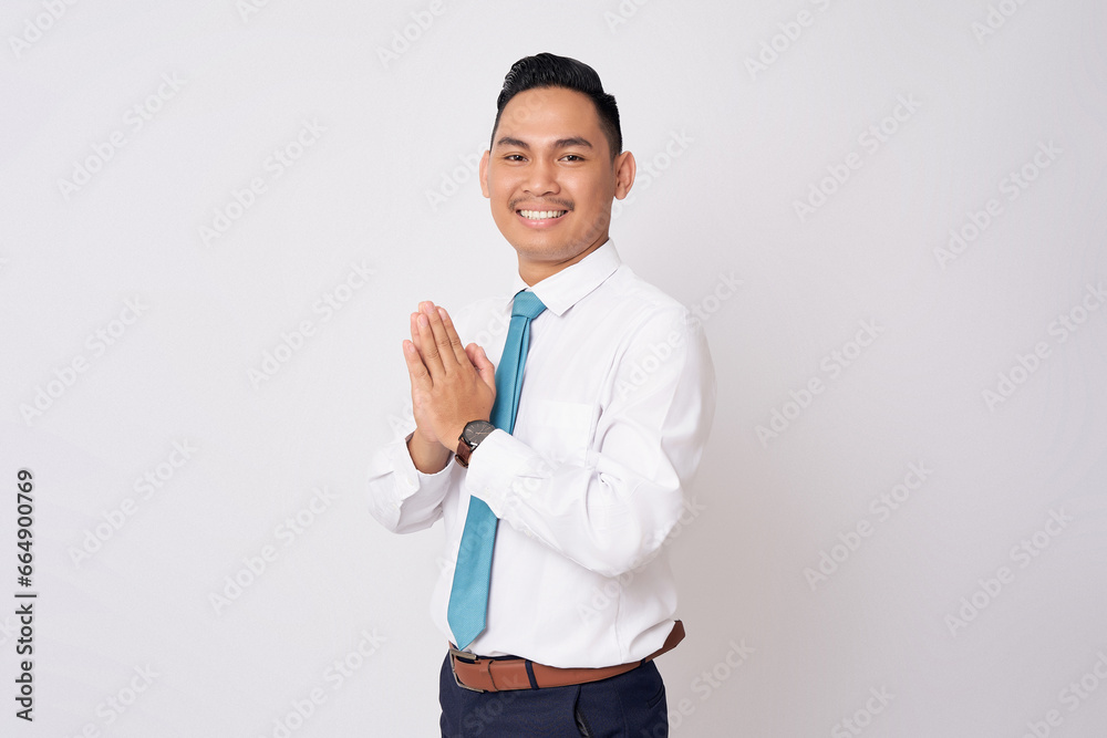 Smiling happy Asian businessman wearing formal shirt and tie standing confident while showing welcome gesture with hands isolated on white background Smiling happy Asian businessman wearing formal shirt and tie standing confident while showing welcome gesture with hands isolated on white background