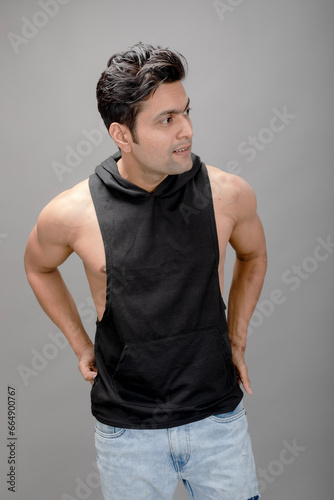 Indian young male model in casual wear wearing black tshirt and blue torn denim jeans. Male model. Fashion Portrait.