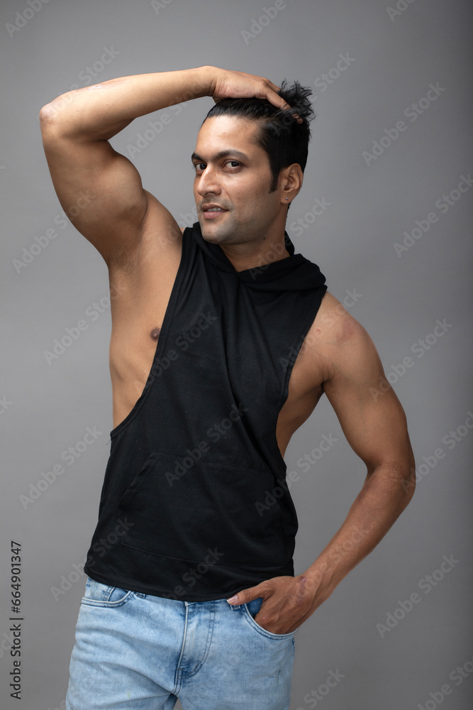 Indian young male model in casual wear wearing black tshirt and blue torn denim jeans. Male model. Fashion Portrait. Indian young male model in casual wear wearing black tshirt and blue torn denim jeans. Male model. Fashion Portrait.