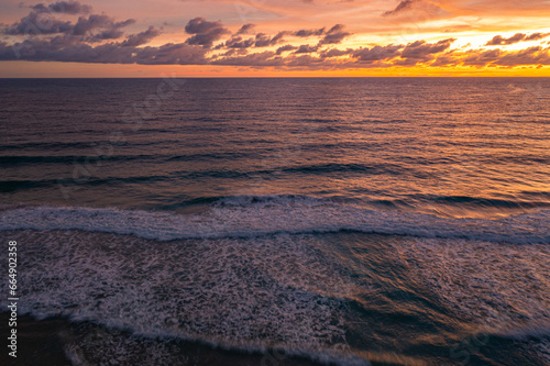 aerial view Wave after wave swept towards the shore at sunset..aerial view Scene of Colorful romantic sky The brilliant yellow sky gradually turned red. .beautiful red sky at sunset in nature