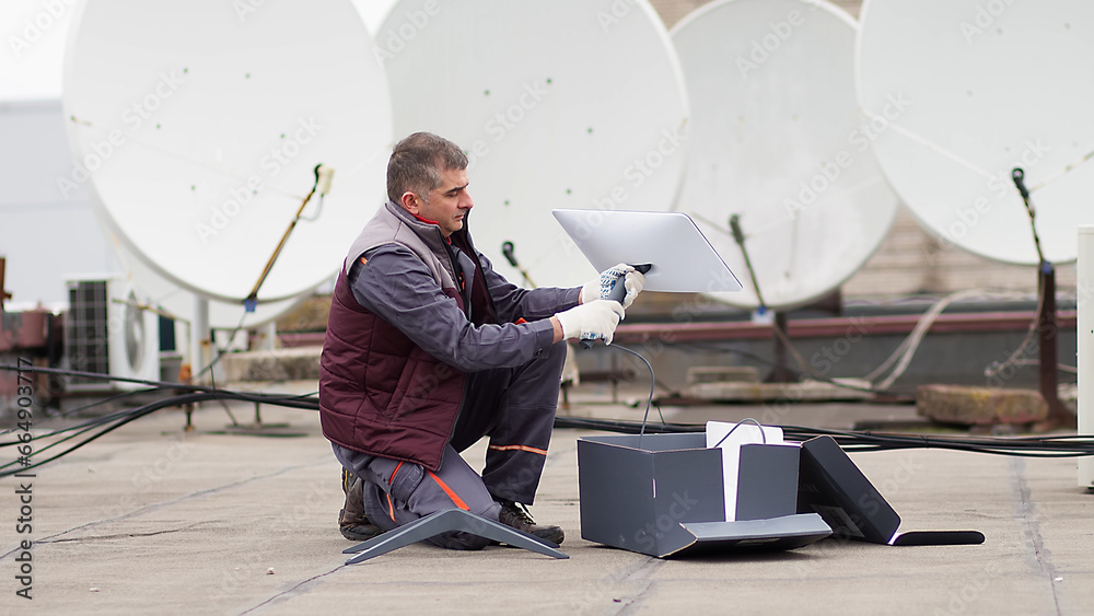 An engineer installs satellite antennas. Work process of