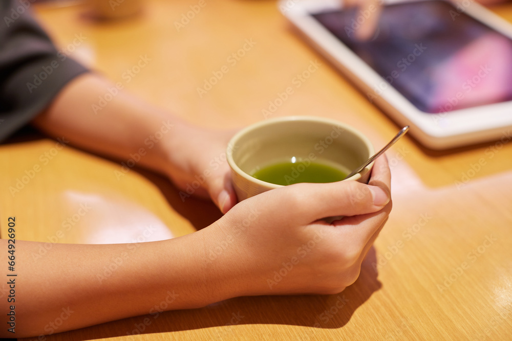 喫茶店でお茶を飲みながら注文する女性の手のアップ写真 喫茶店でお茶を飲みながら注文する女性の手のアップ写真