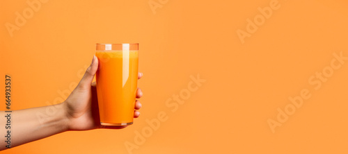 carrot juice in a woman's hand on a yellow background Generative AI