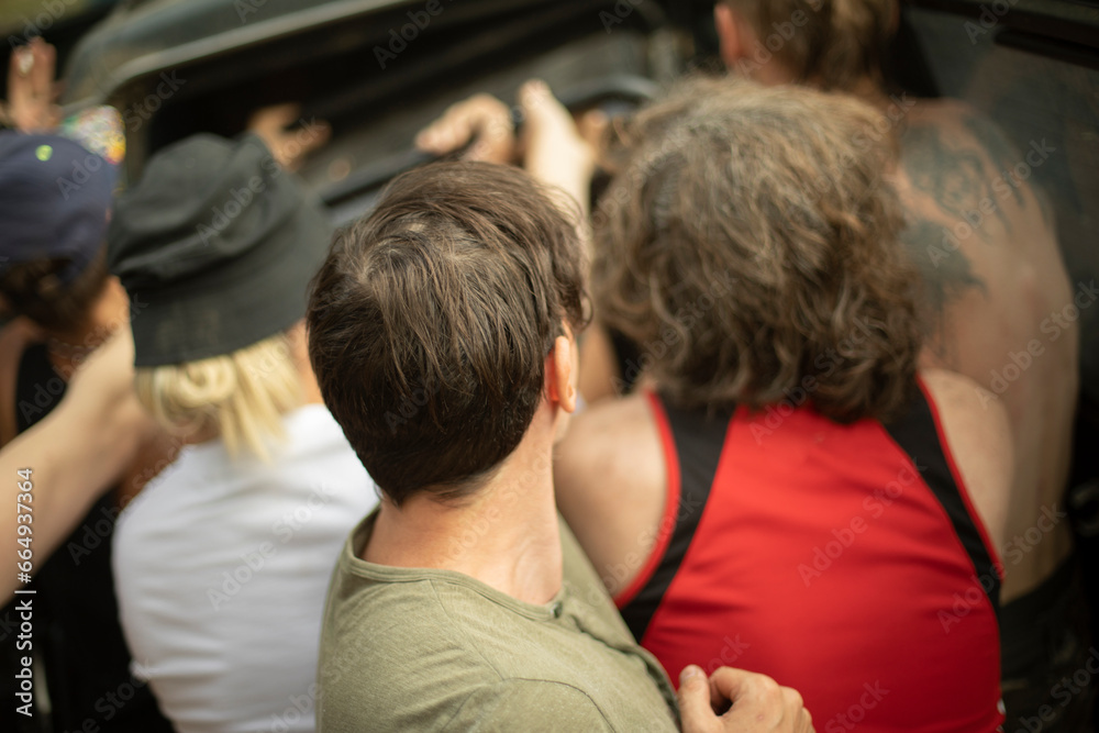 Obraz premium People load things into car. Guy holds heavy load. Tourists load transport.