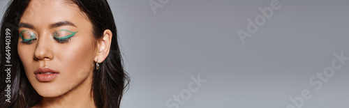 portrait of beautiful asian woman with brunette hair, shimmery eye makeup and closed eyes, banner