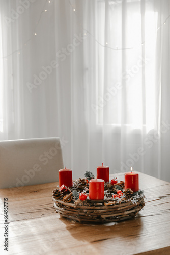 Advent wreath with first candle lit on advent sunday. Table centerpiece, cozy home before Christmas.