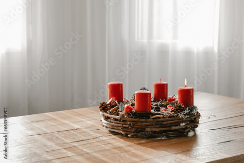 Cozy modern home with advent wreath on dining table. Celebrating winter time and days before Christmas in Switzerland.