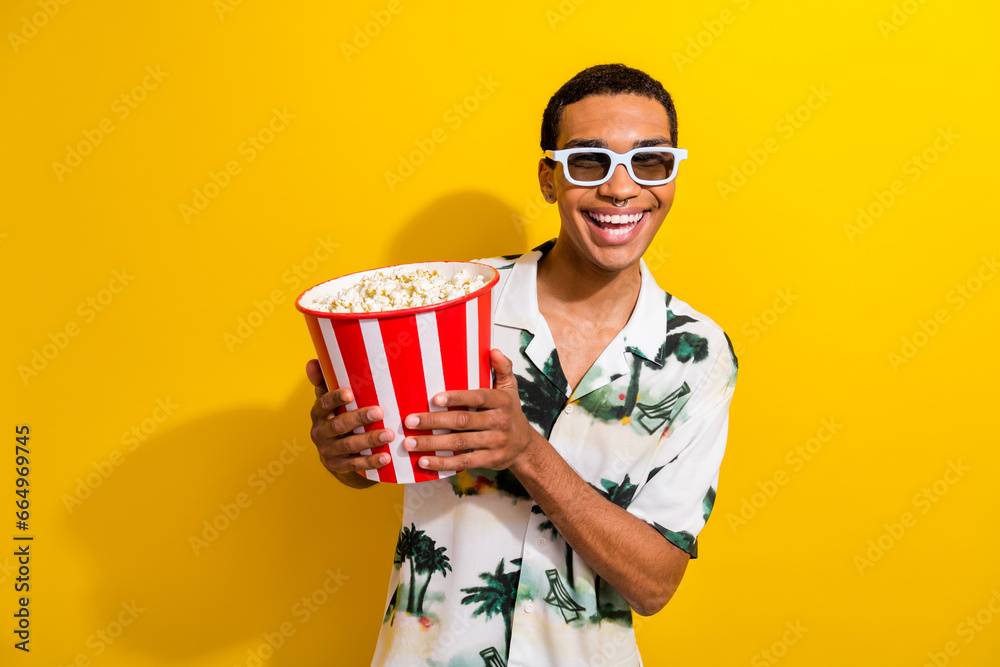 Photo of cheerful cool guy wear stylish outfit hand hold tasty popcorn enjoy comedy film isolated on vibrant yellow color background - obrazy, fototapety, plakaty 