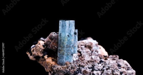 blue aquamarine with schorl (black tourmaline) inclusion rotating 360° in 4k isolated on black background. macro detail close-up rough raw unpolished semi-precious gemstone.
