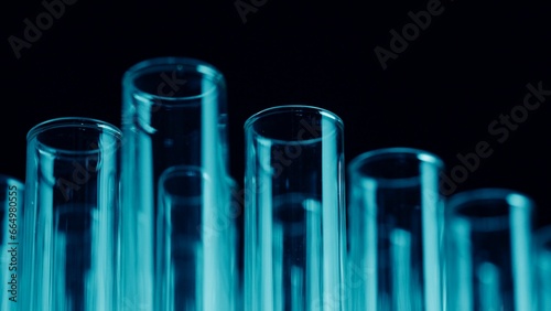 Close up photo neon blue light test tubes in a laboratory. Scientific experiment, research, study. Detail shot of lab glassware.