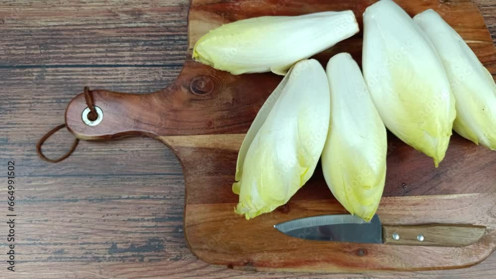 plusieurs endives crues sur une planche à découper