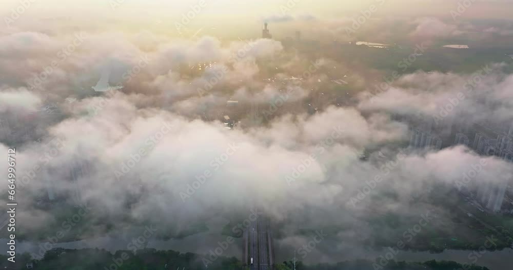 Drone flying above the clouds overlooking the ground. Aerial view of residential area buildings and sky clouds landscape at sunrise in Jiashan County, Jiaxing, Zhejiang, China. Drone flying above the clouds overlooking the ground. Aerial view of residential area buildings and sky clouds landscape at sunrise in Jiashan County, Jiaxing, Zhejiang, China.