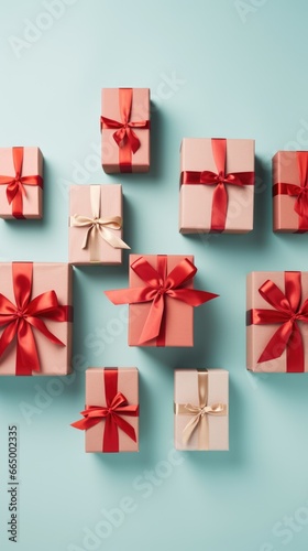 An array of gift boxes, wrapped in pink paper, adorned with red and gold ribbons, set against a light teal backdrop © Polea