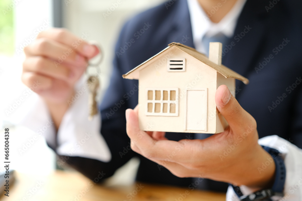 Hand of man holding model house. Mortgage, home loan, real estate insurance and banking concept. Hand of man holding model house. Mortgage, home loan, real estate insurance and banking concept.