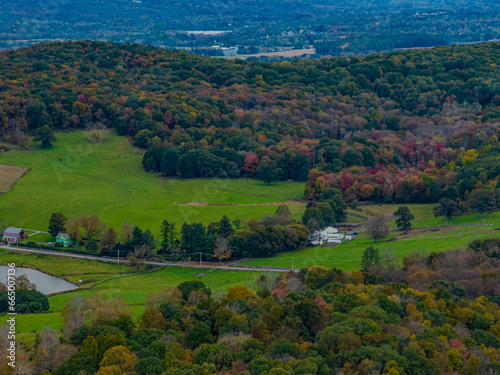 Aerial view of the countryside in Stormville, New York on a day with dark clouds, during the colorful autumn season.