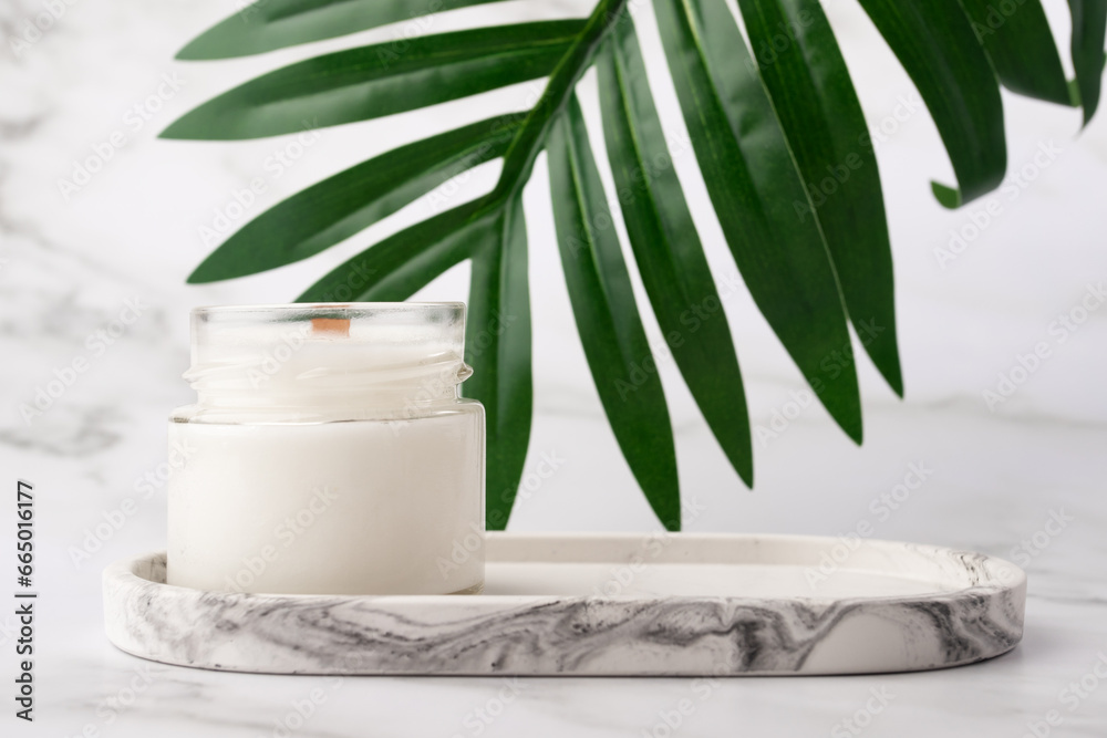 aromatic Candle on a marble tray in the bathroom with green leaf, spa atmosphere, cozy home aromatic Candle on a marble tray in the bathroom with green leaf, spa atmosphere, cozy home