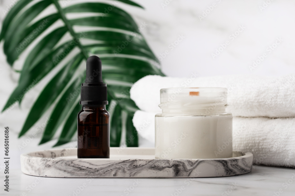 aromatic candle with oil serum in the bathroom on a marble tray with towels, home spa, facial skin,health and beauty cosmetics aromatic candle with oil serum in the bathroom on a marble tray with towels, home spa, facial skin,health and beauty cosmetics