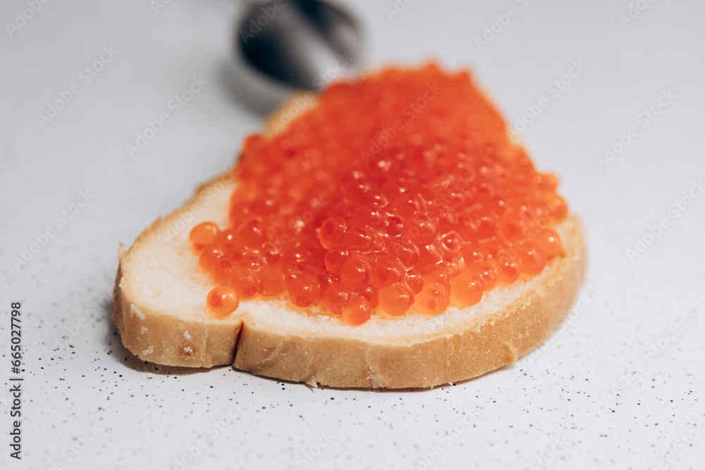 A sandwich with red caviar lies on the table. Healthy eating for weight loss bread and salmon caviar