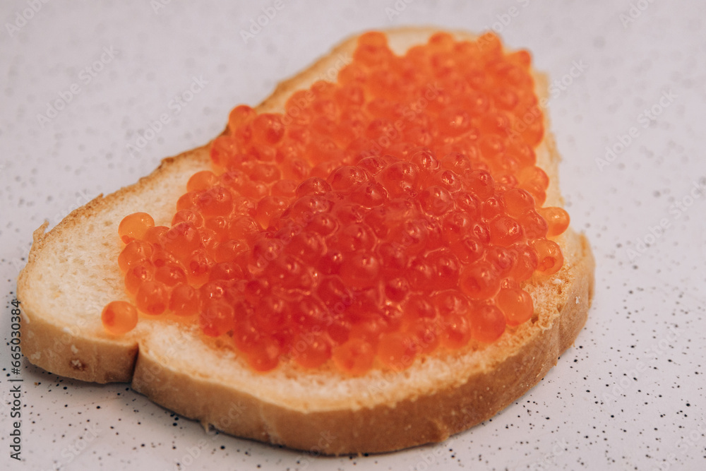 A sandwich with red caviar lies on the table. Healthy eating for weight loss bread and salmon caviar A sandwich with red caviar lies on the table. Healthy eating for weight loss bread and salmon caviar