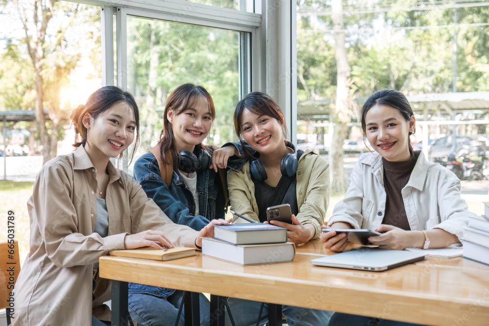 Group of cheerful Asian college students or friends laughing together while sitting in university. Group of cheerful Asian college students or friends laughing together while sitting in university.