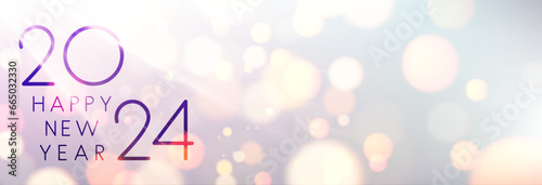 New Year 2024 color gradient horizontal banner with beautiful sun rays and blurred yellow round lights.