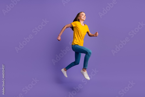 Fototapeta Naklejka Na Ścianę i Meble -  Full length photo of girl having fun jumping up running speed isolatedpurple color background