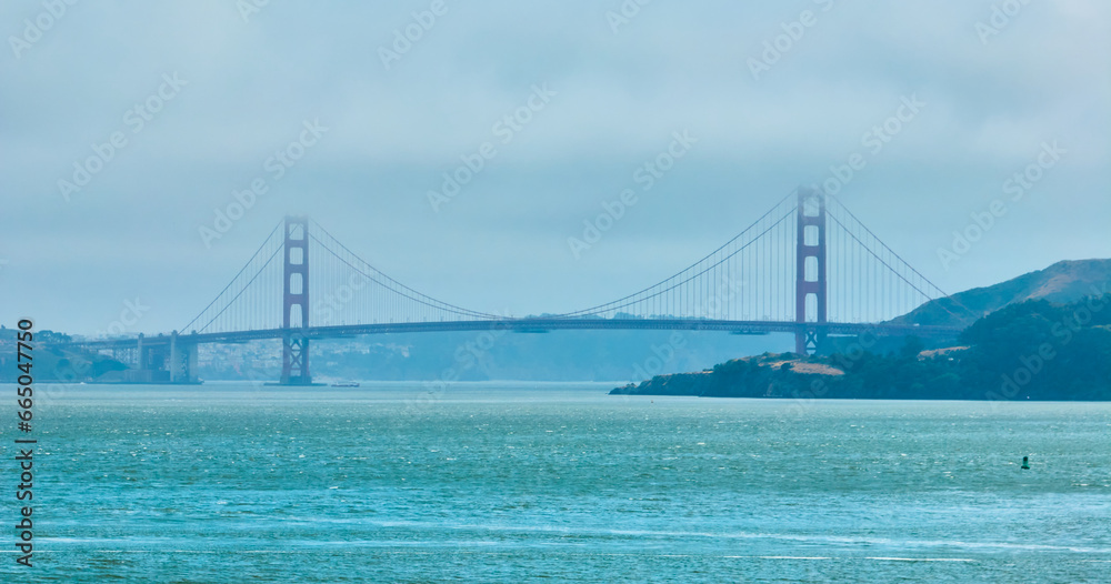 Golden Gate Bridge covered in hazy fog aerial of full bridge side view