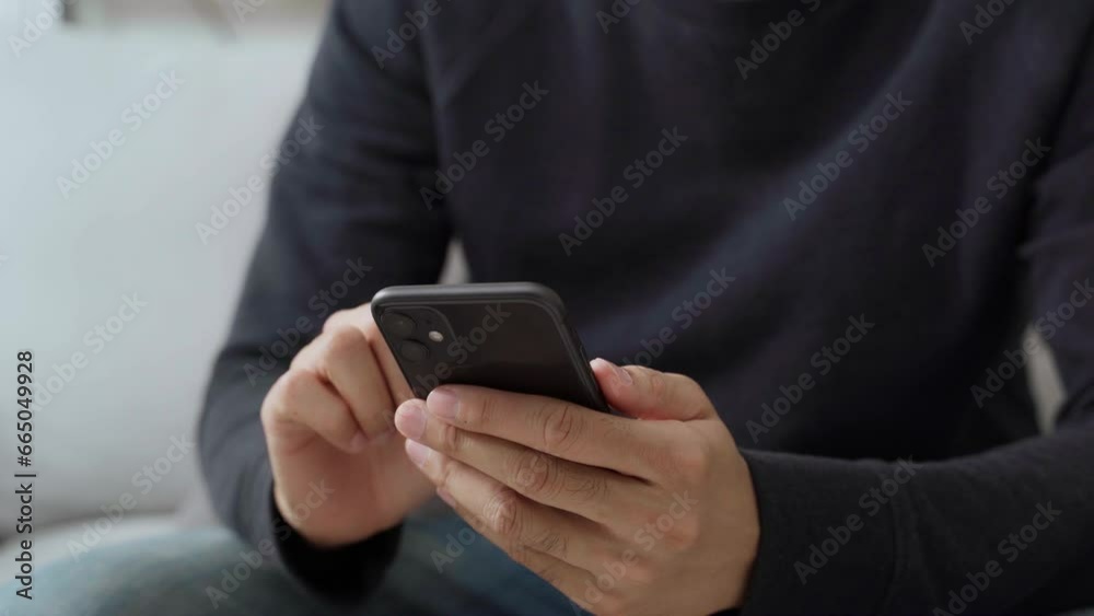 The young man's hand is using a smartphone to access the internet and searching for information, social network. The young man's hand is using a smartphone to access the internet and searching for information, social network.