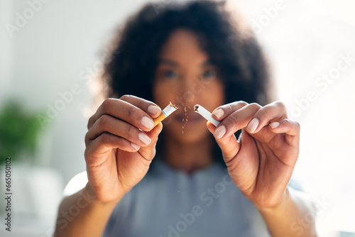 Woman breaking down cigarette to pieces. Quit smoking concept