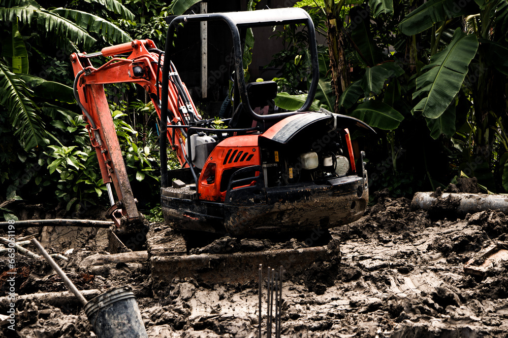 mini excavator with a bucket on a construction site against the