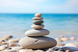 Torre de piedras lisas en la orilla de una cala o playa rocosa.