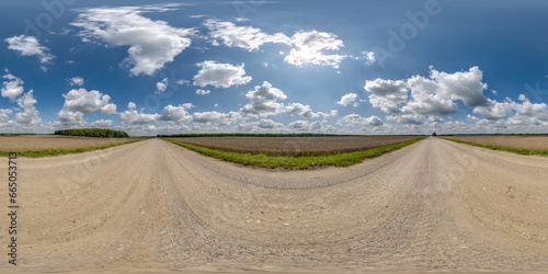 360 hdri panorama on wet gravel road with marks from car or tractor tires with clouds on blue sky in equirectangular spherical seamless projection, skydome replacement in drone panoramas