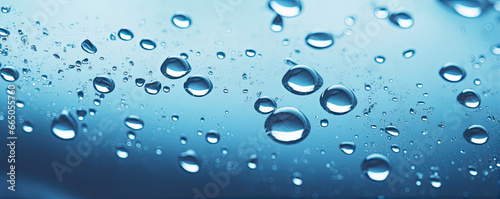 Water or oil drops on glass surface in blue colors. Dropslet close up.