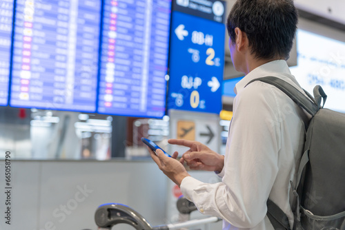 Wallpaper Mural Business man using mobile phone to book plane ticket through online application, sitting on travel checking travel time on board at airport, travel, payment, due, booking, online, check in Torontodigital.ca