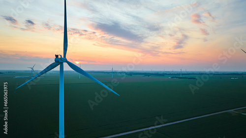 Sunset over green farmland and wind turbine farm aerial pretty skies