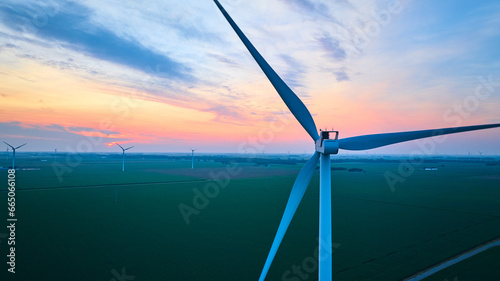 Gorgeous pinks and blues with orange glow at sunset over aerial of wind farm in farmland photo